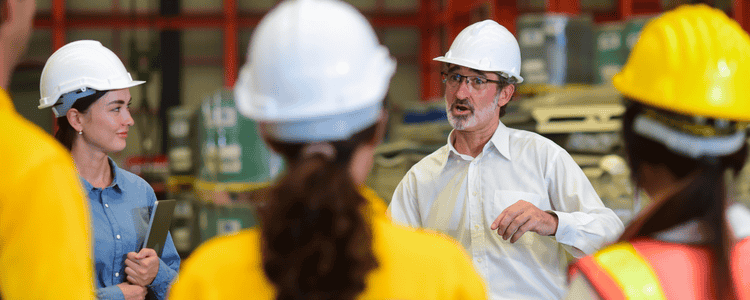 A project lead speaks to construction team in a huddle